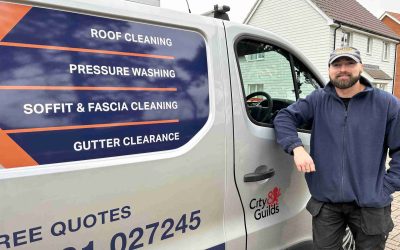 Roof cleaning specialist standing next to van.